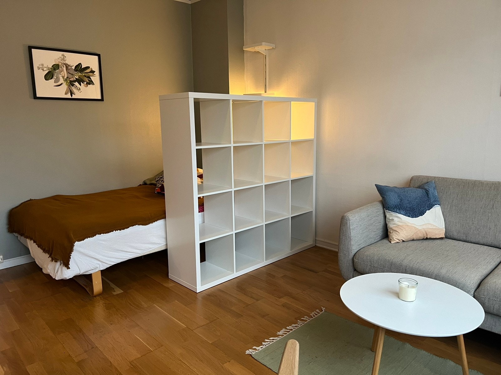 En hylle skjermer sengen fra resten av oppholdsrommet Galleribilde