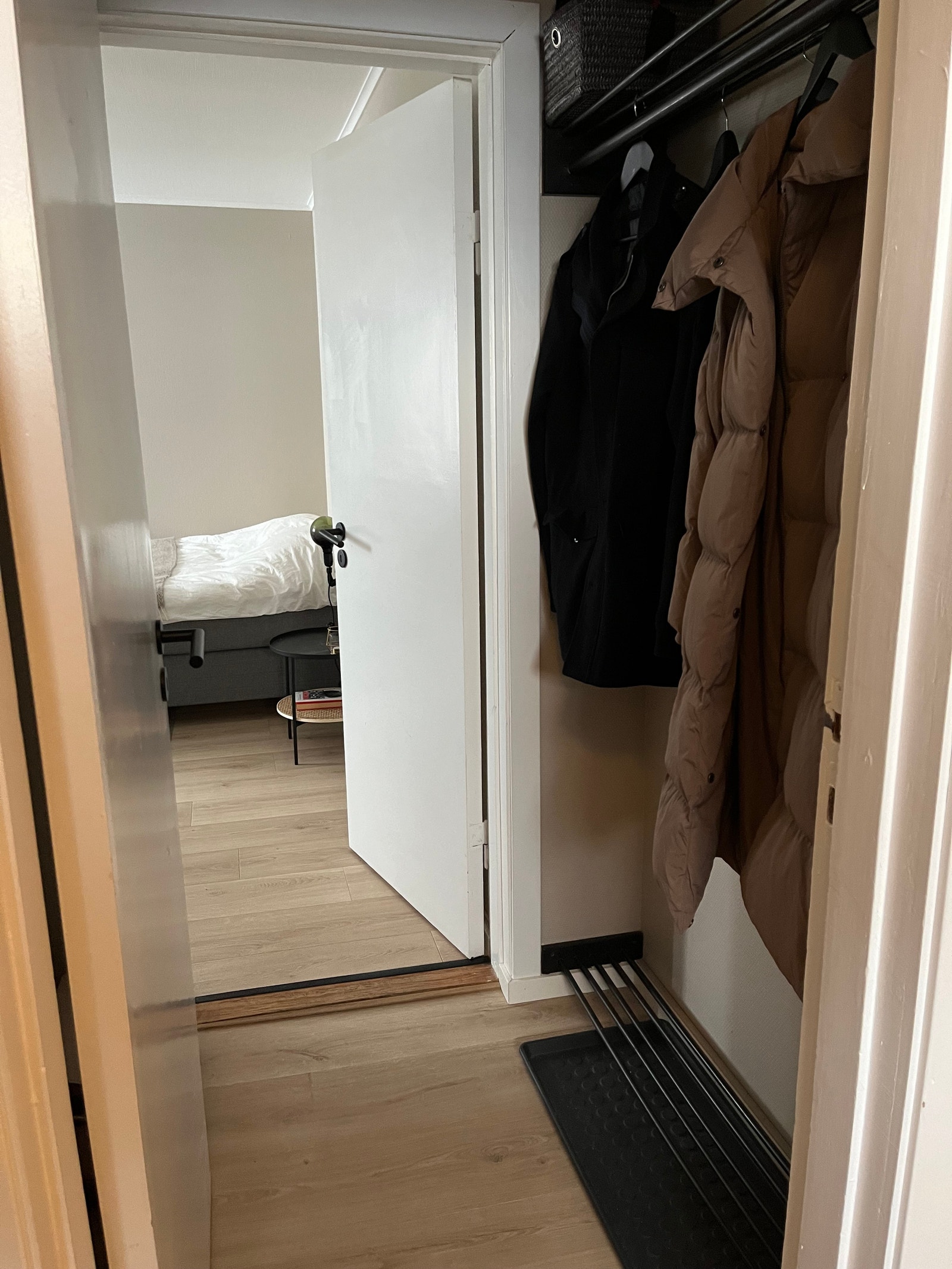 En liten entre med plass til noen jakker og sko Galleribilde