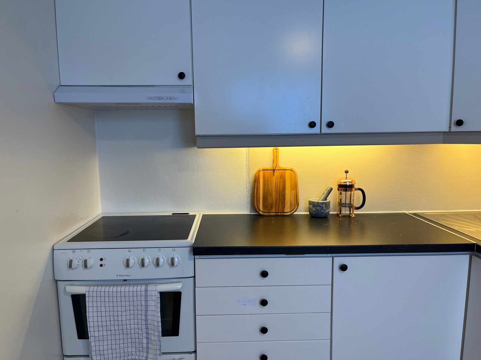 Et koselig kjøkken med god lagringsplass i skap og skuffer Galleribilde