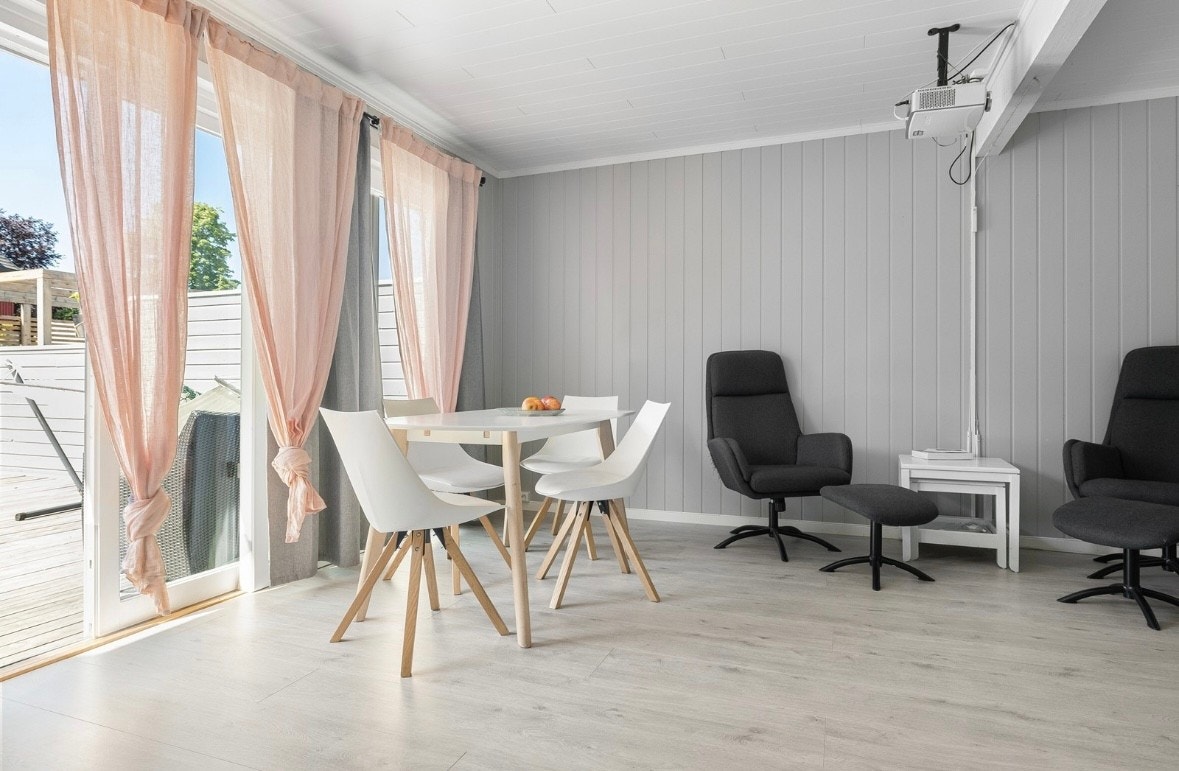 Stuen har mange vindusflater og skyvtett som slipper inn mye naturlig lys Galleribilde