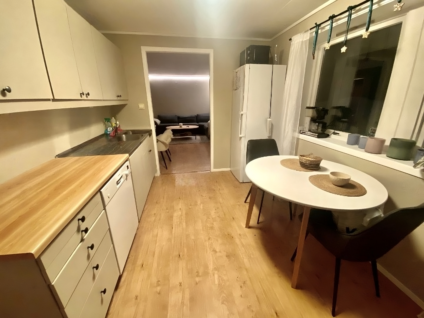 Kjøkken med bor, kjøleskap, oppvaskmaskin og komfyr. Galleribilde