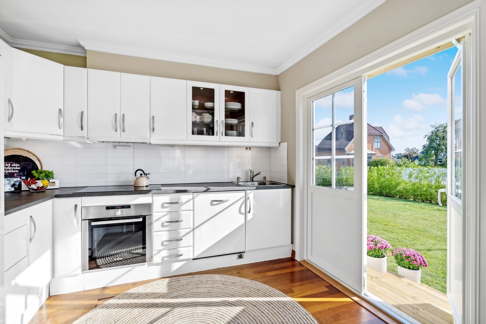 Fra kjøkkenet har du utgang til eiendommens hage. Perfekt på fine sommerdager! Galleribilde