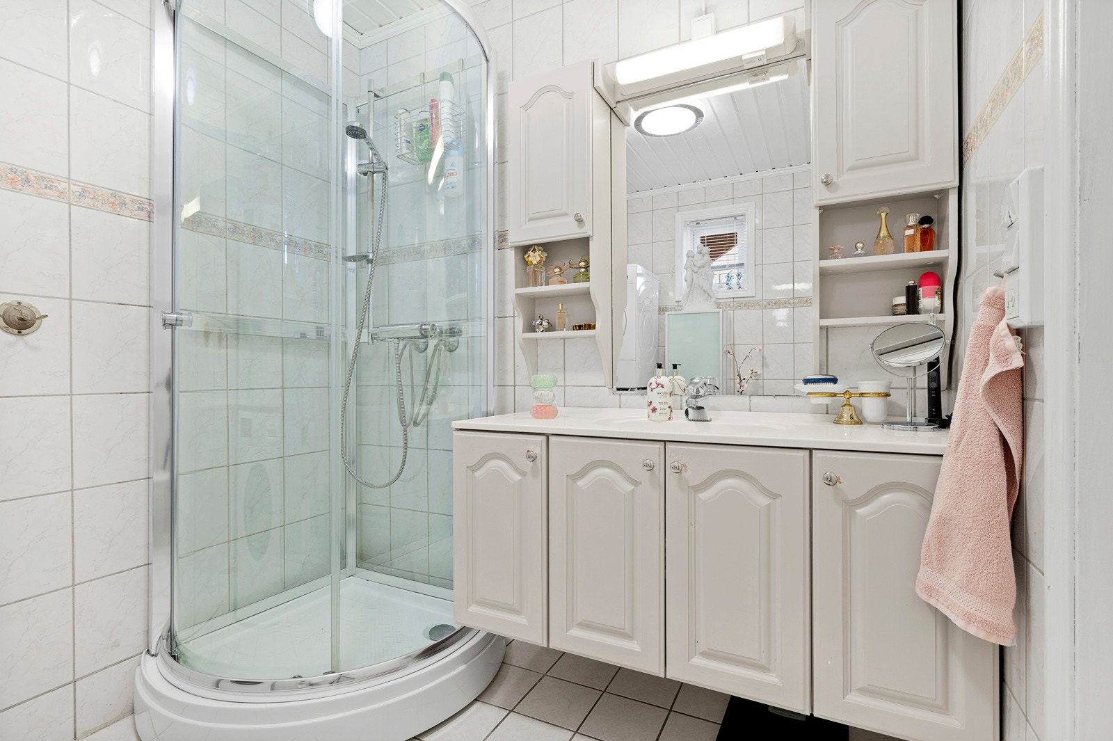 Badet har toalett, dusjkabinett, servant med innredning og opplegg til vaskemaskin. Galleribilde