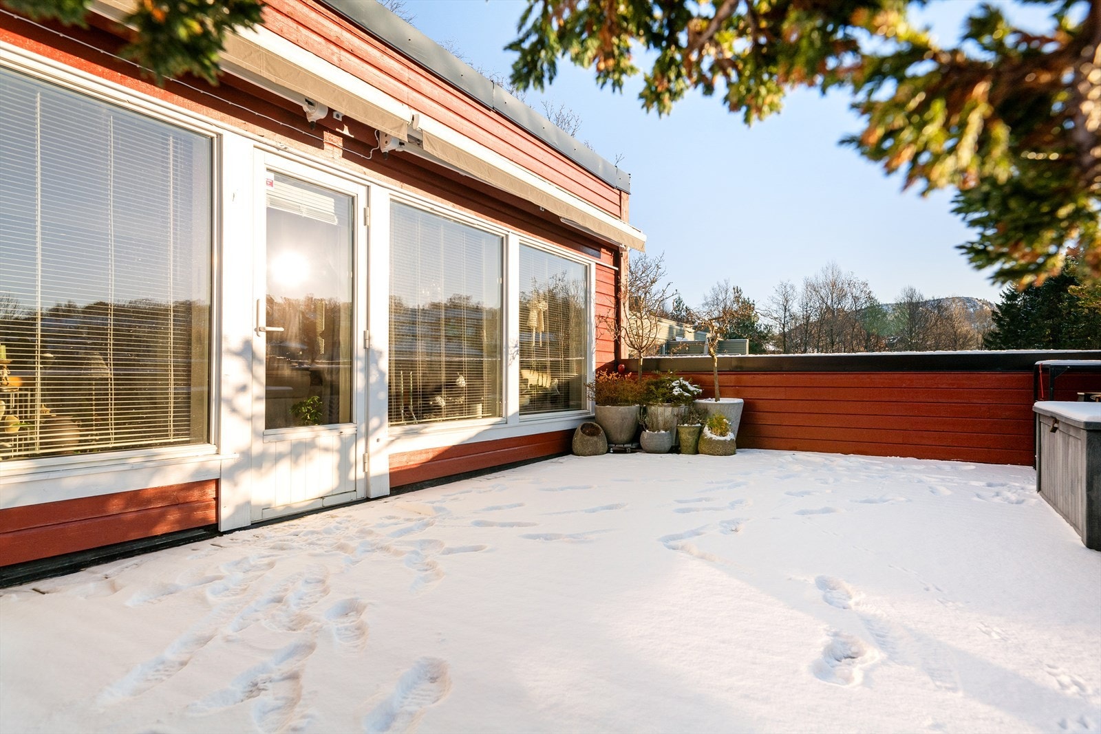 Fra stuen er det utgang til en stor, herlig terrasse, med flott, vid utsikt over nærliggende bolig- og naturområder. Her kan man enkelt innrede i ulike soner, og terrassen innbyr til hyggelige grillmiddager og andre sosiale sammenkomster. Galleribilde