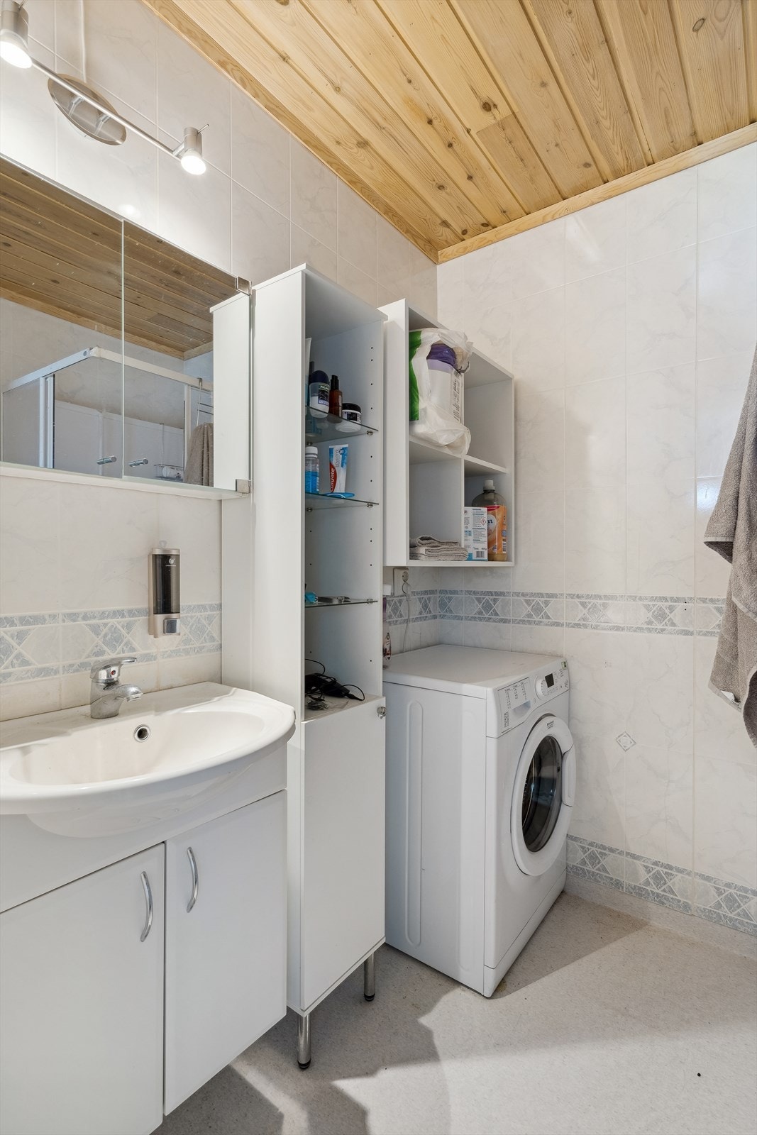 Badet inneholder: toalett, dusjkabinett, opplegg for vaskemaskin, speilskap, varmeovn og innredning med vask. Galleribilde