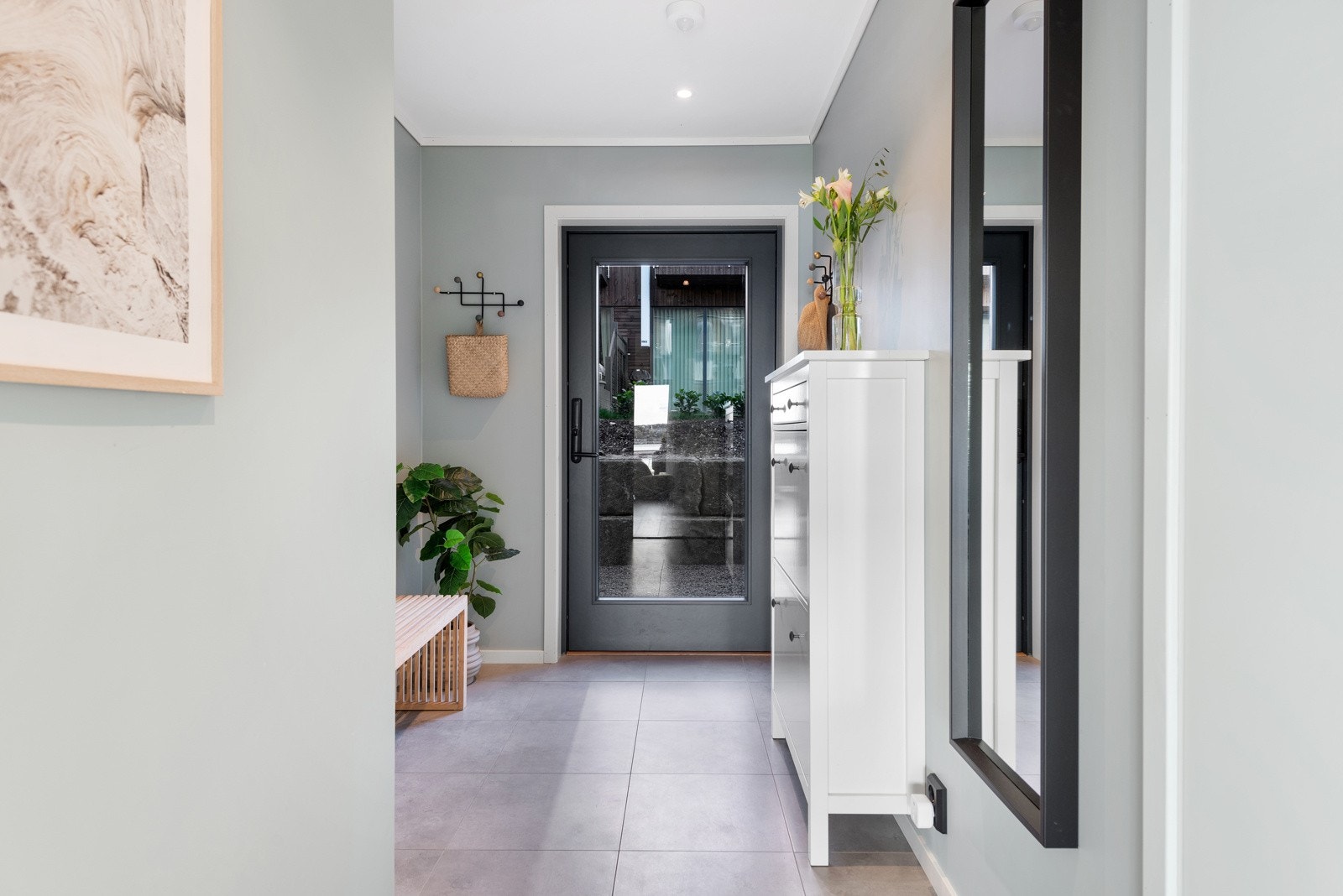 Entreen har store, delikate gulvfliser og slette vegger malt i en trendy farge. Galleribilde
