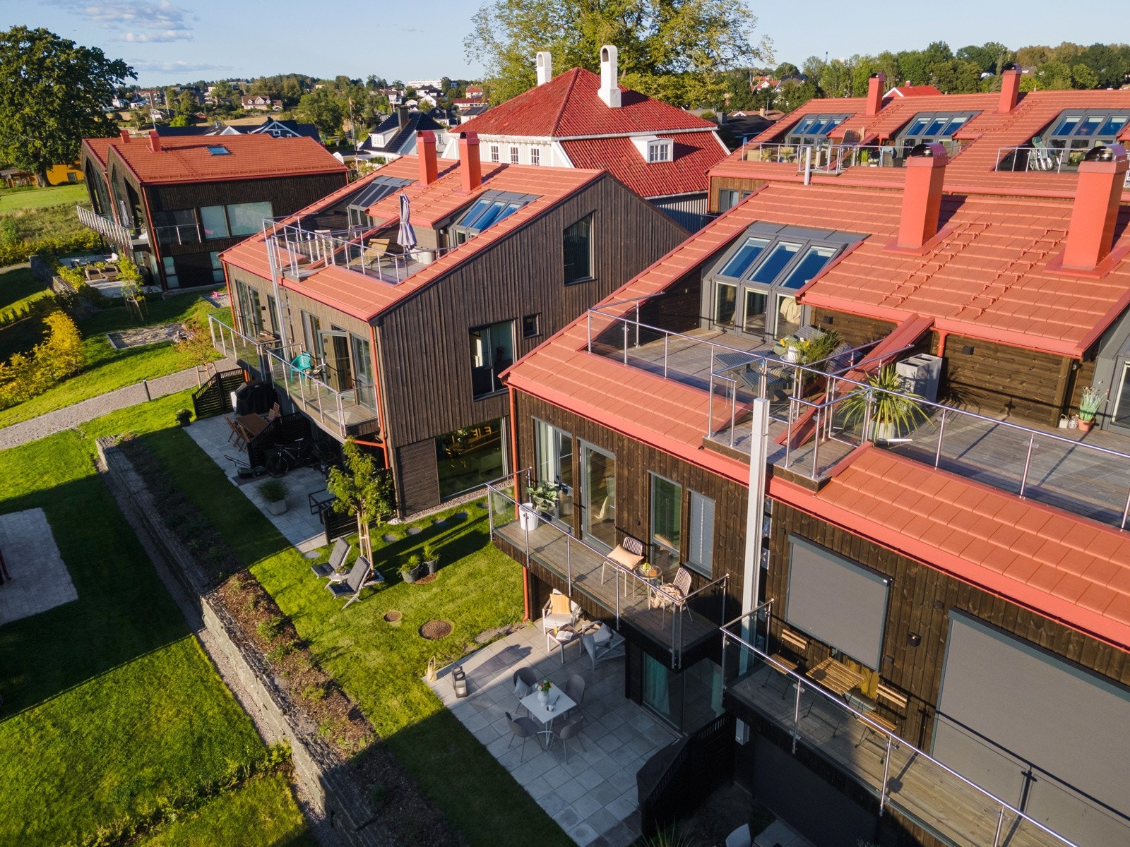 Felleseiendommen har gode solforhold, og det er pent opparbeidet med plen, trær, avgrensede hekk og støttemur mot boliger i fremkant. Galleribilde