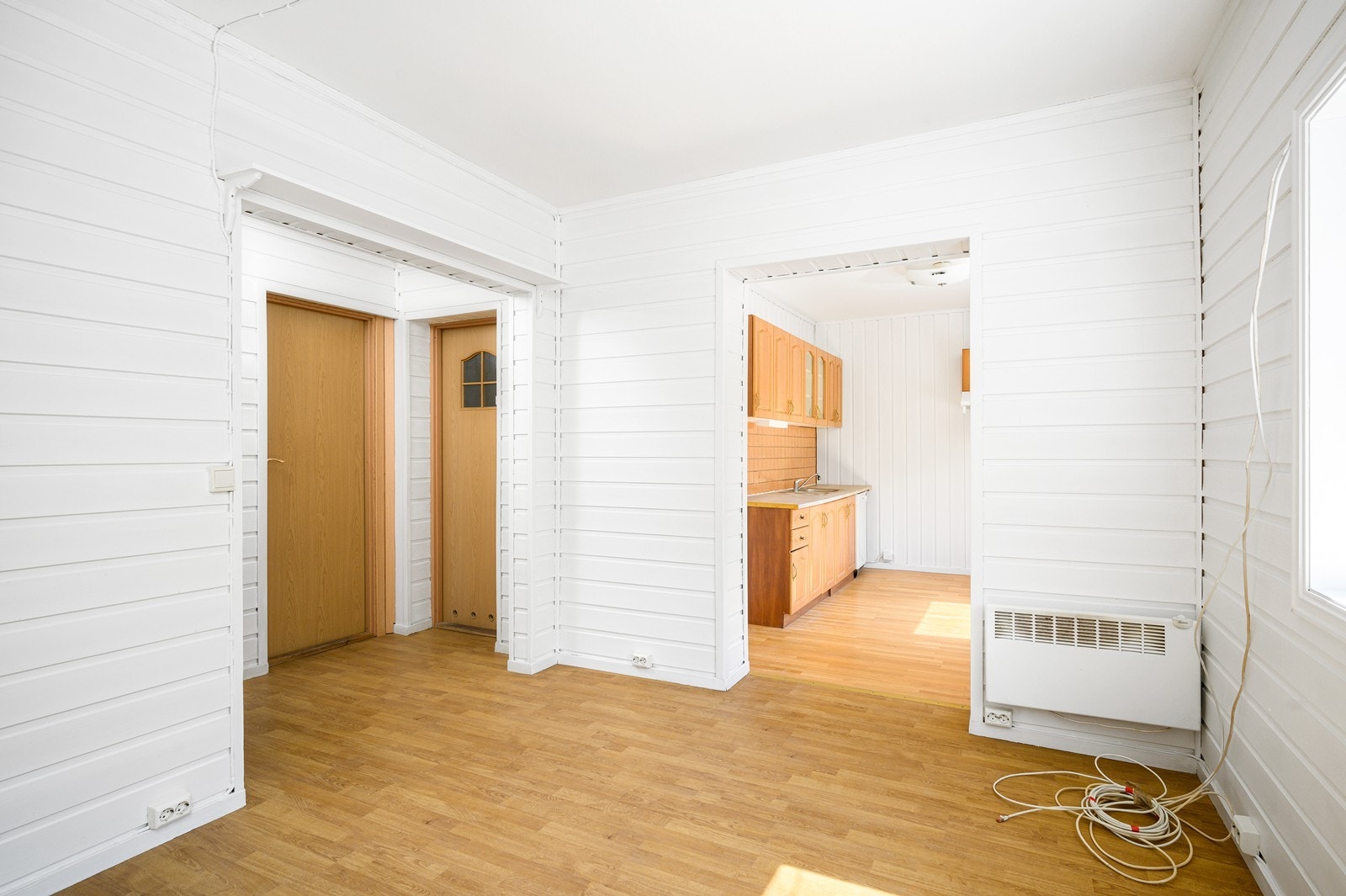 Innvendige vegger består i hovedsak av hvitmalt panel og på gulvet er det laminat Galleribilde