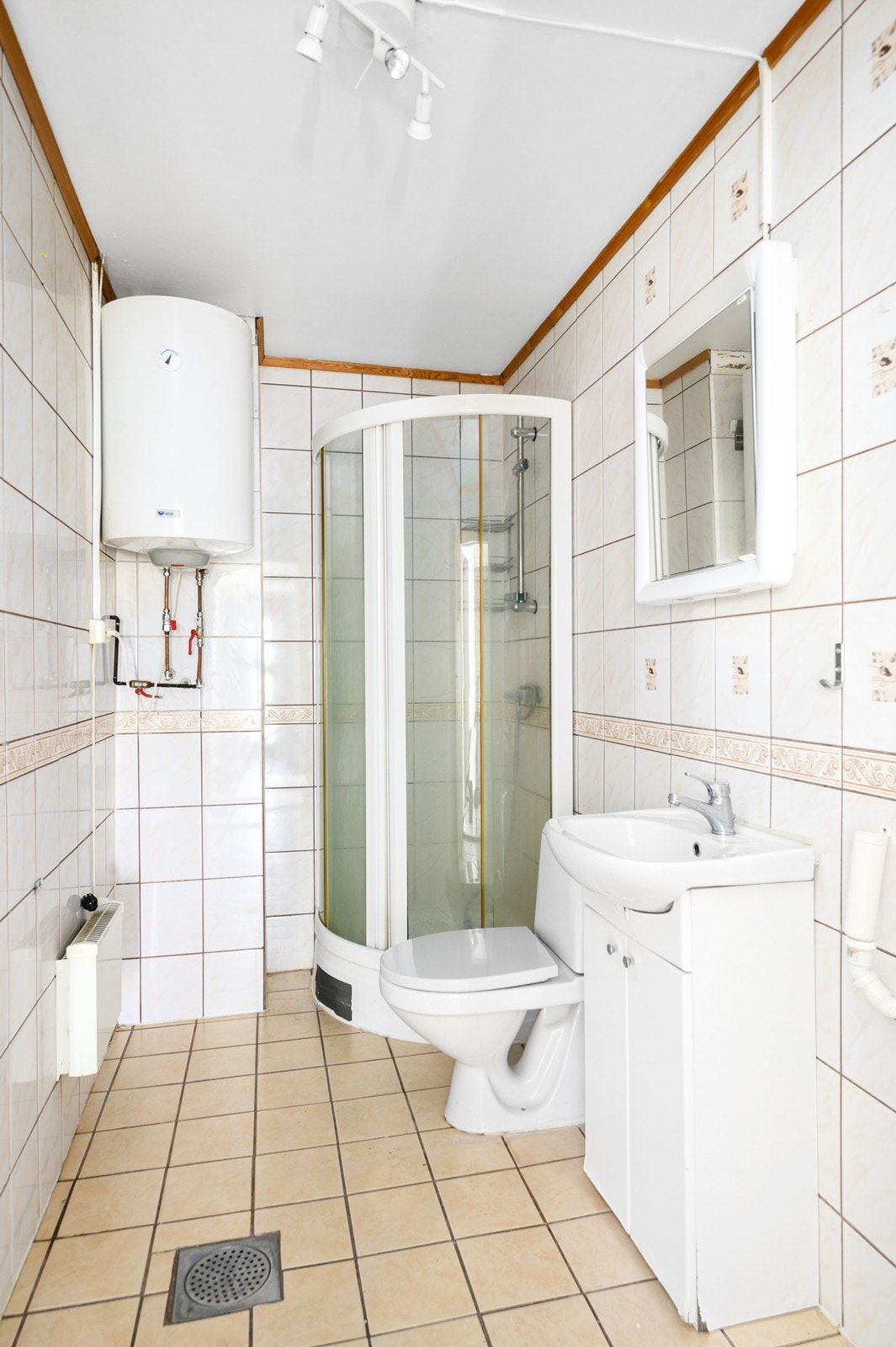 Gulv og vegger er flislagt - uten varme i gulvet, og badet er innredet med wc, servant i skapinnredning og dusjkabinett Galleribilde