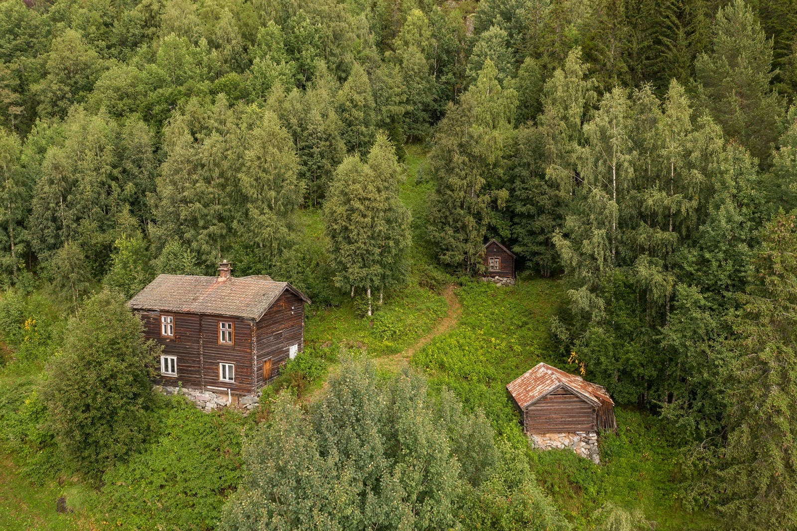 Gamlestua til venstre og vedskjul/uthus til høyre. I bakkant ligger snekkerbua Galleribilde