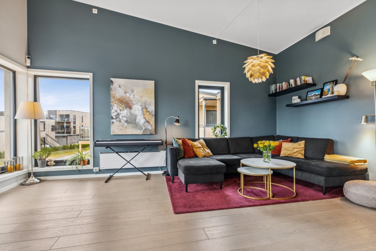 Store vinduer slipper inn rikelig med dagslys i stuen. Det er montert plissegardinger til solskjerming på vinduene innvendig. Galleribilde