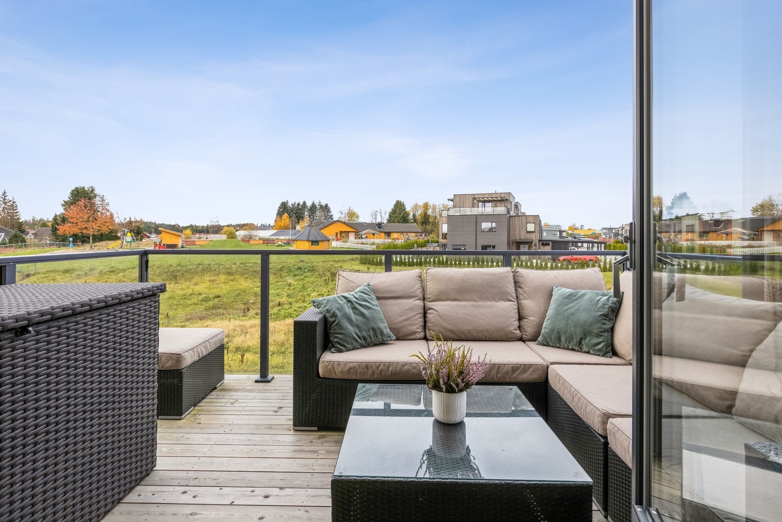 Verandaen har utsyn mot blant annet grøntområde like utenfor leiligheten. Verandaen har også utsyn til nyetablert lekeplass like nedenfor sameiet. Galleribilde
