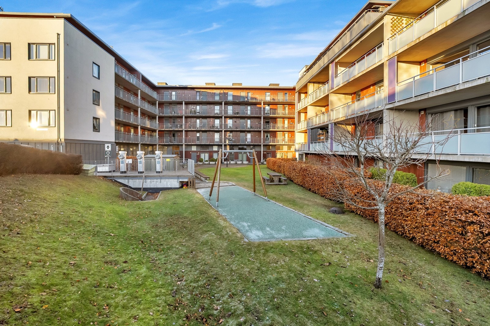 Fellesområdet er pent opparbeidet med grøntarealer, sittegrupper, lekeapparater, diverse beplantning, stemningsfull belysning og asfalterte gangstier. Galleribilde