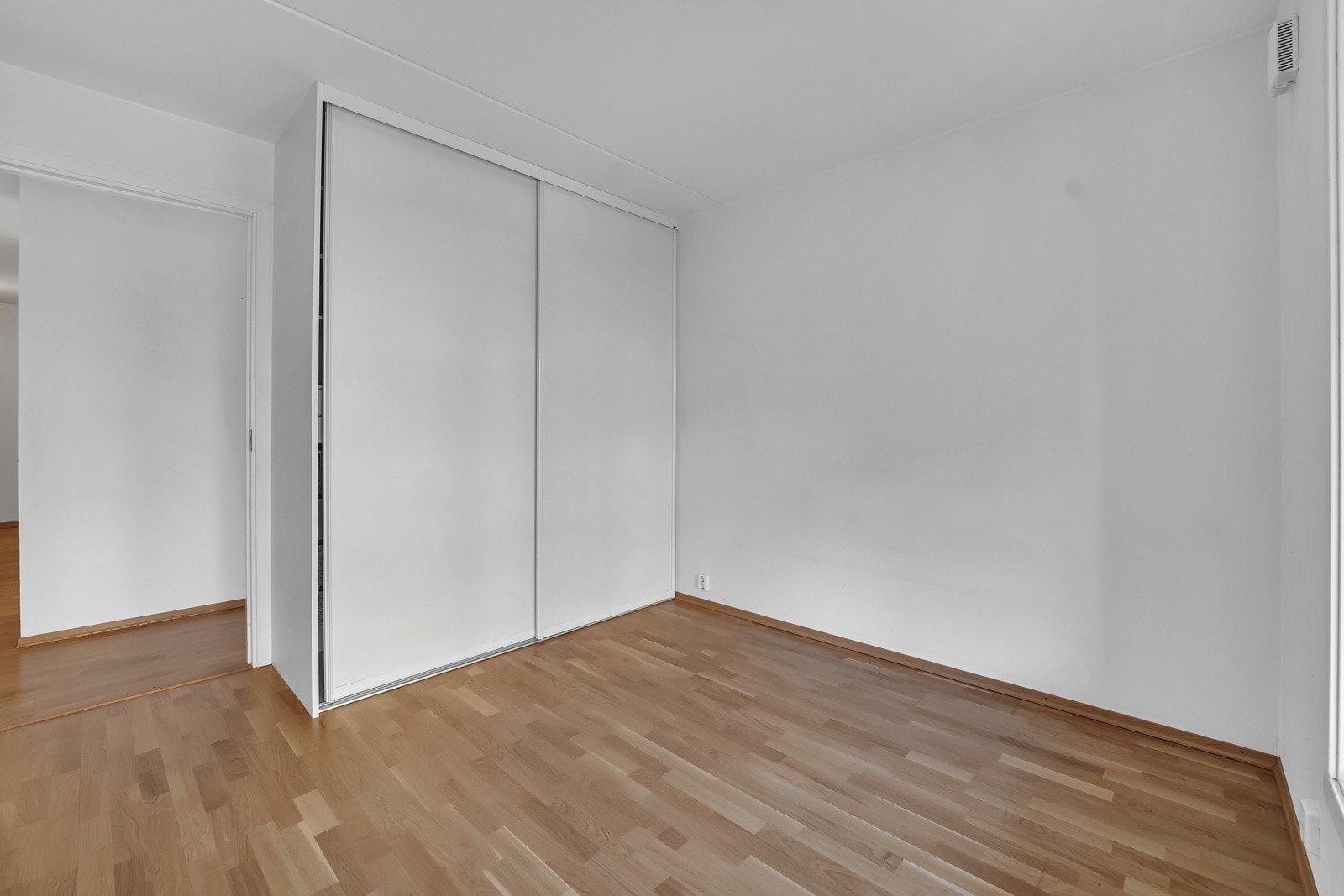 På hovedsoverommet er det en plassbygget skyvedørsgarderobe med hvite fronter. Galleribilde