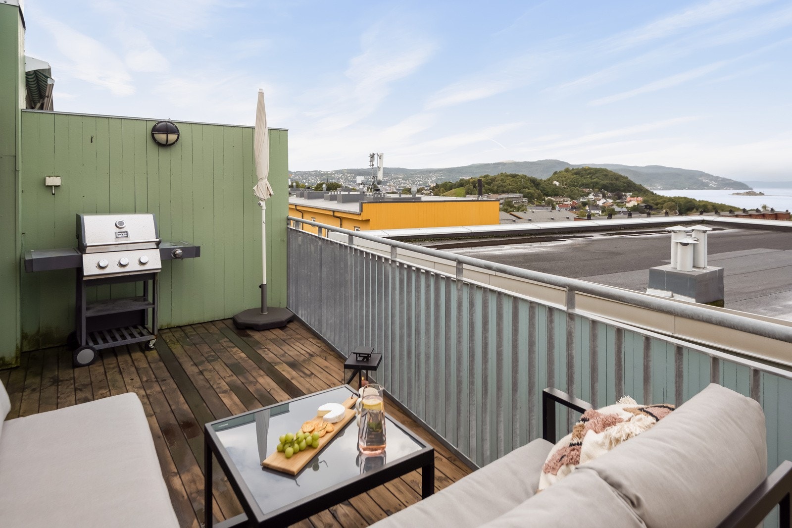 Utsikten fra toppetasjen går over hustakene i front mot fjorden i det veletablerte boligfeltet. Galleribilde