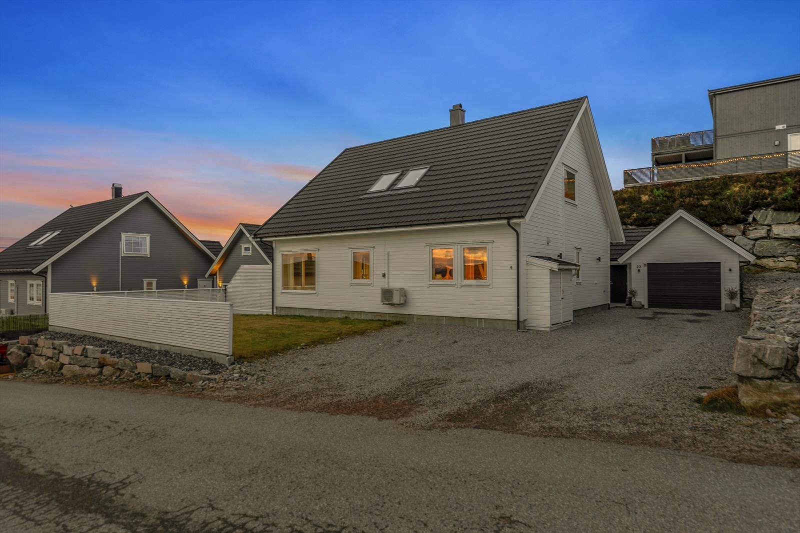 Hage med gruset oppkjørsel og garasje med utebod. Galleribilde