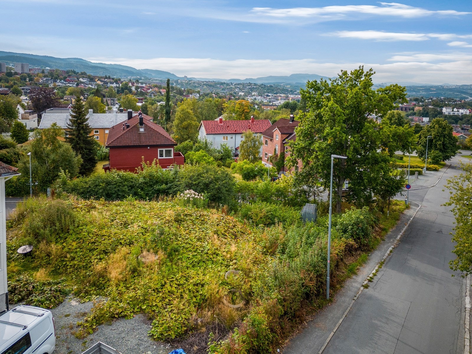 Tomten kan skilte med vid, flott utsikt utover nabolag og mot byen, med fjellene som pent bakgrunnsteppe. Galleribilde