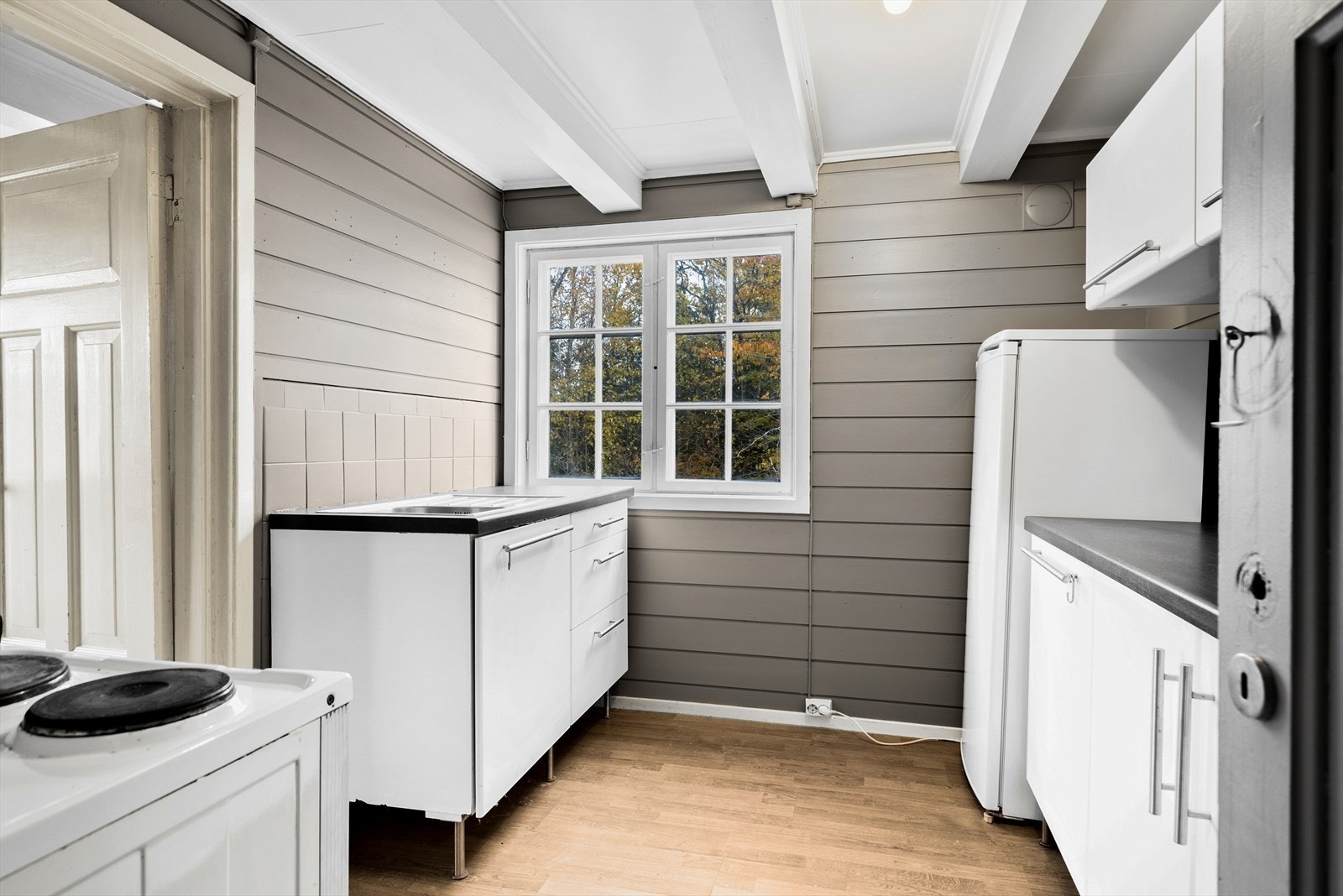 Kjøkkeninnredning med slette fronter. Malte fliser/malt panel over benk. Galleribilde