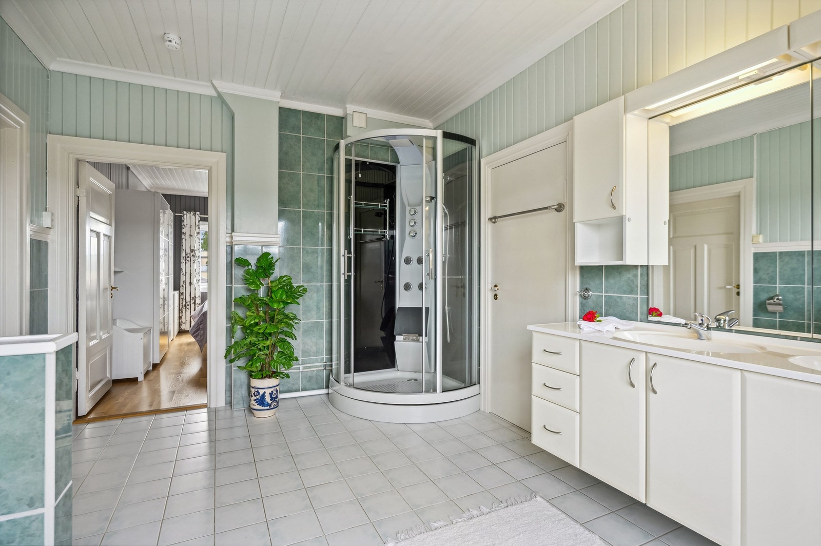 Fra badet er det adkomst både til hovedsoverommet og til en bod med innredet kott Galleribilde