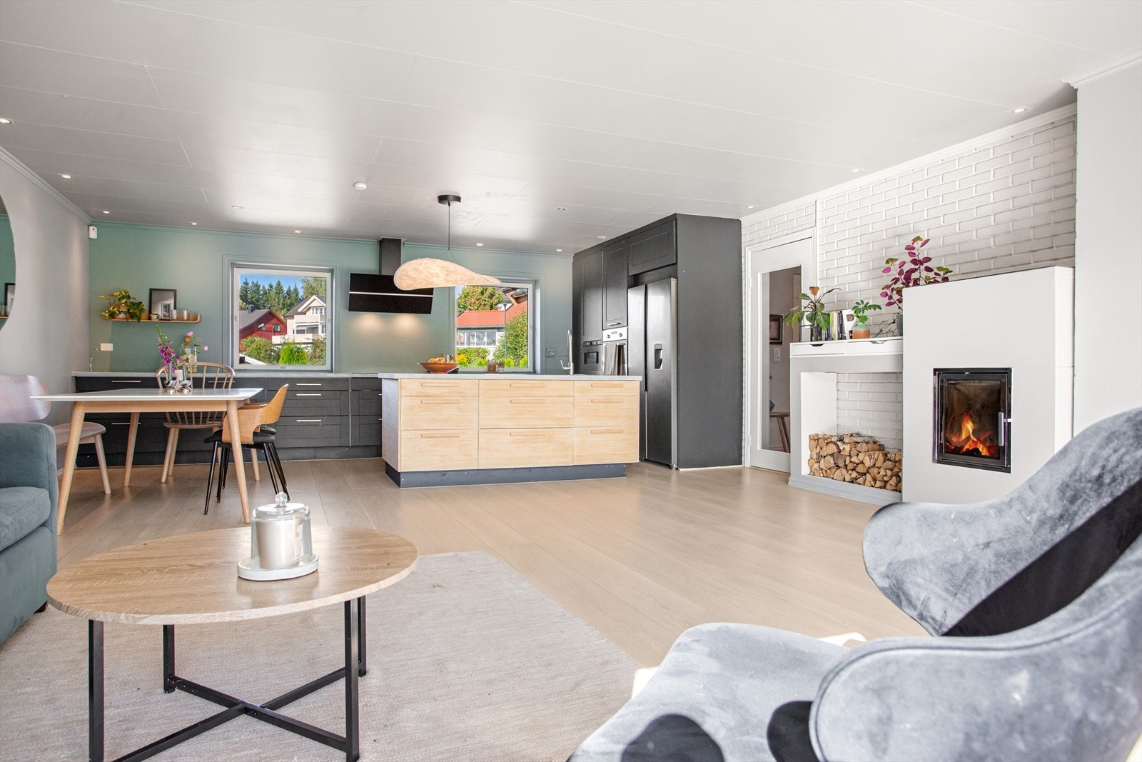 Stue og kjøkken er naturlig inndelt i egne soner - men oppleves likevel som ett, sosialt oppholdsrom. Galleribilde