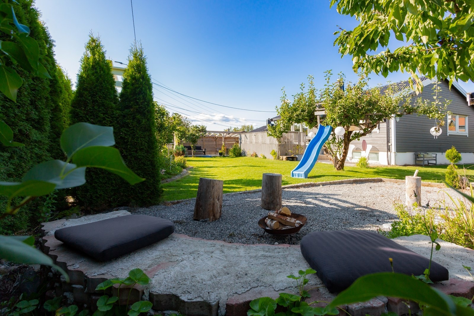 Eiendommen har flotte uteplasser med solrike terrasser, pent opparbeidet hage, tujahekk, dukkestue og bålpanne. Galleribilde