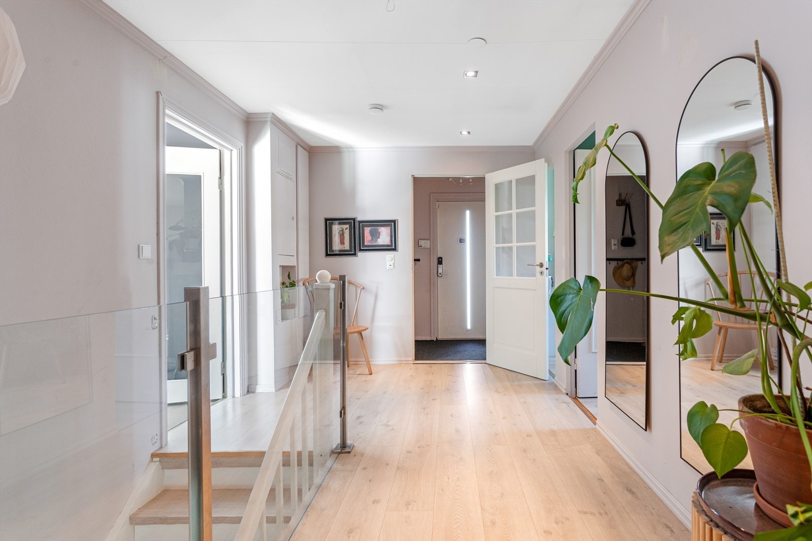 En lys og innbydende entré gir et flott førsteinntrykk av boligen. Fra entréen er det videre adkomst til mellomgang med tilgang til resten av rommene og trapp opp ned til underetasjen. Galleribilde