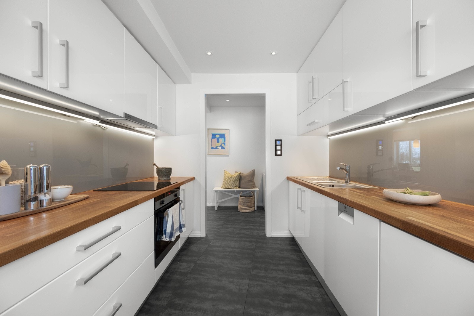 Kjøkkenet er utstyrt med komfyr, oppvaskmaskin og nedfelt platetopp, samt integrert kjøleskap med frysedel. Det er ventilator i overskap over platetoppen Galleribilde