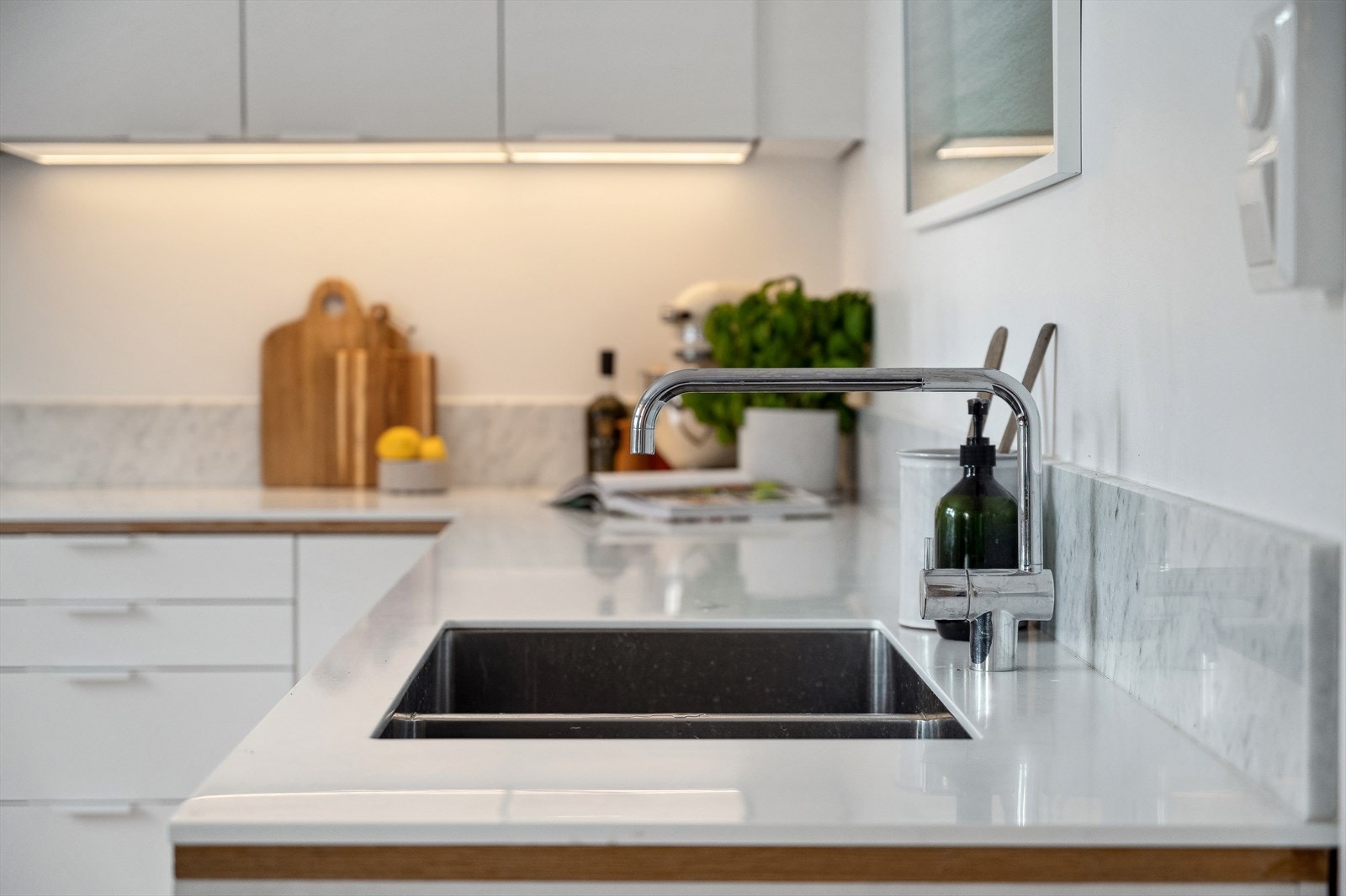 Delikat Corian benkeplate med nedfelt kum og oppkant i marmor. Galleribilde