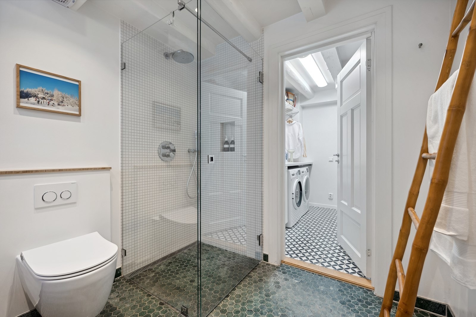 Rommet har flislagt gulv med behagelig gulvvarme og det er flislagte vegger i dusjsonen. Direkte adkomst til vaskerom fra badet. Galleribilde