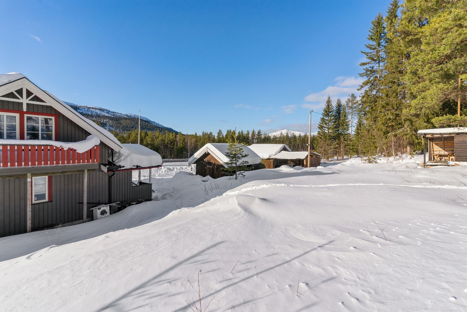 På eiendommen er det flere eldre bygninger - uthus med carport og uthus med hobbyrom Galleribilde