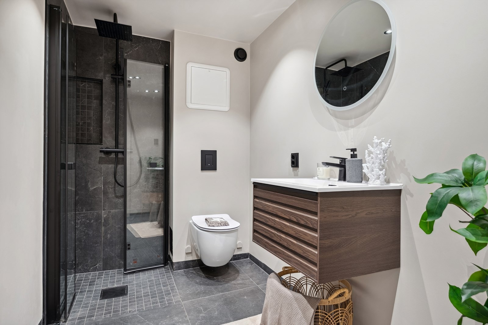 Delikat baderom som har flislagt gulv med elektriske varmekabler. Det er opplegg for vaskemaskin her. Galleribilde