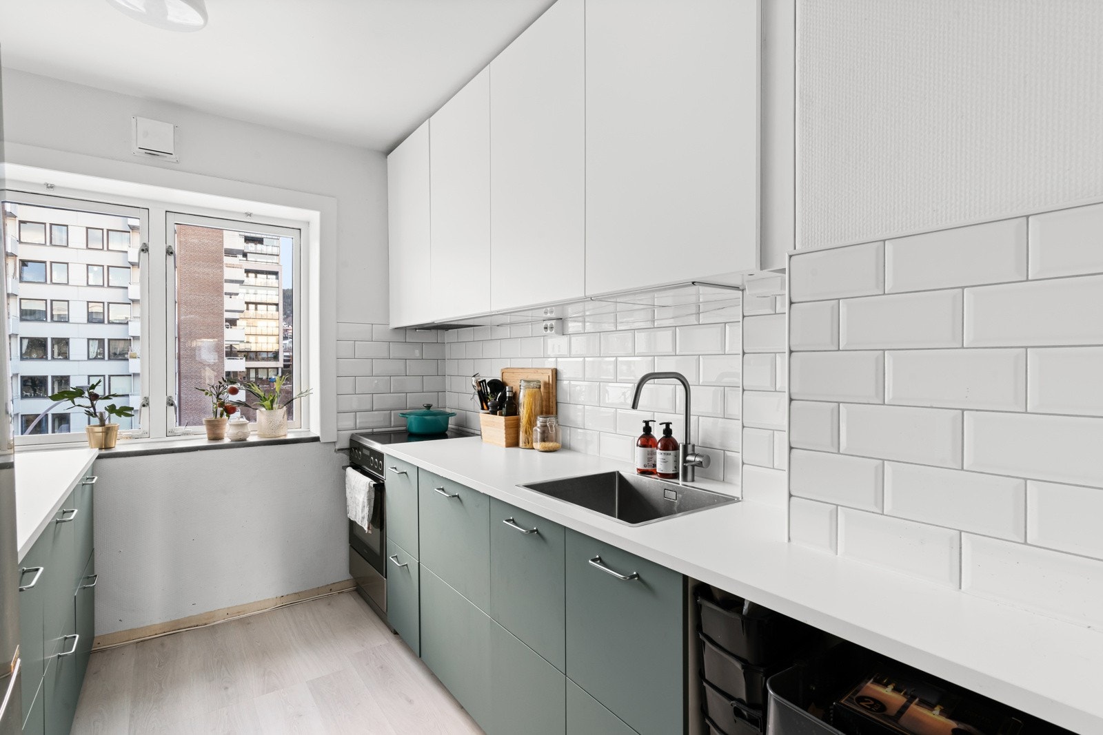 Innenfor entreen har leiligheten et separat kjøkken med moderne innredning og mye naturlig lys. Galleribilde