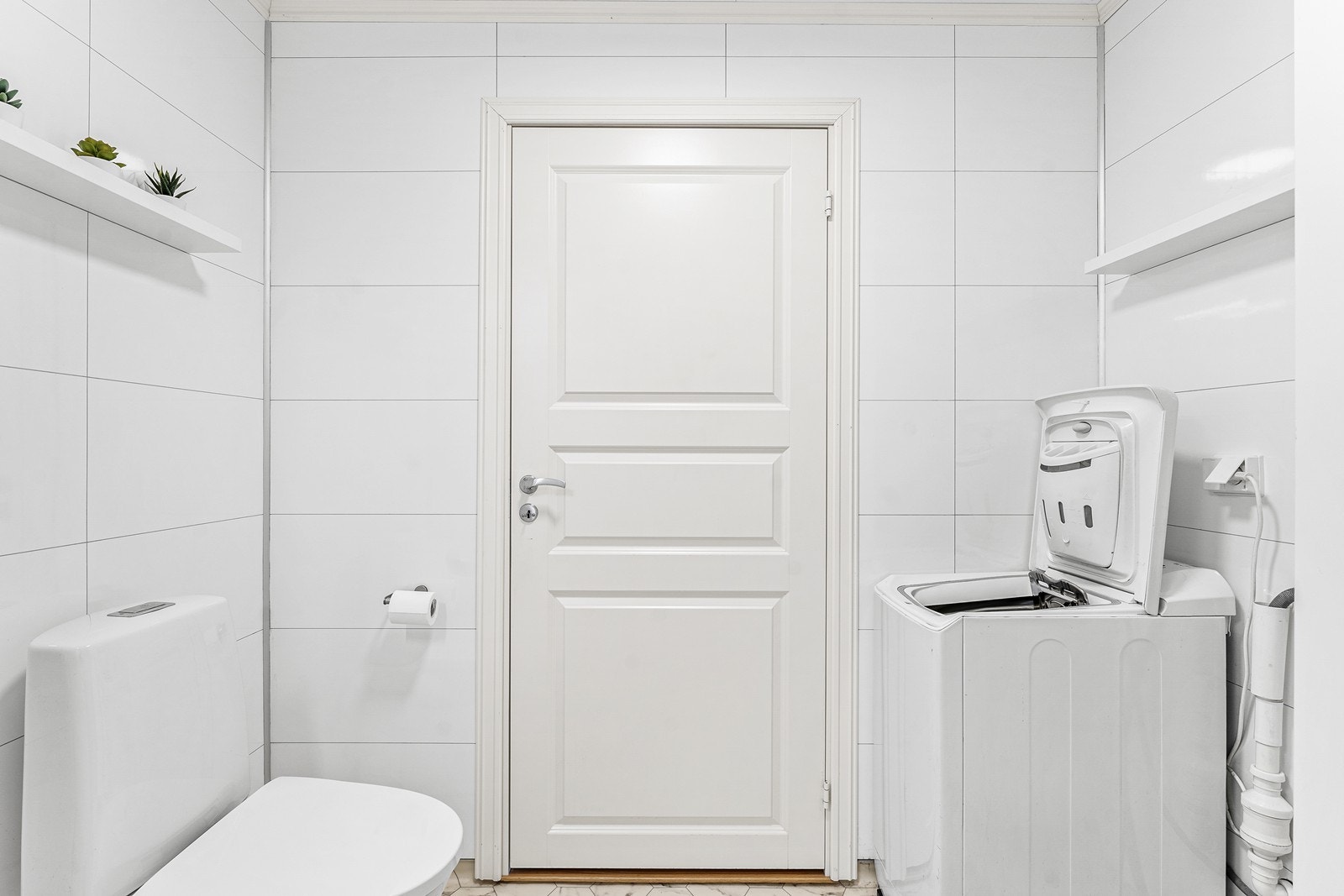 Badet er ellers innredet med vaskemaskin, toalett, baderomsinnredning med vask og dusjkabinett. Galleribilde