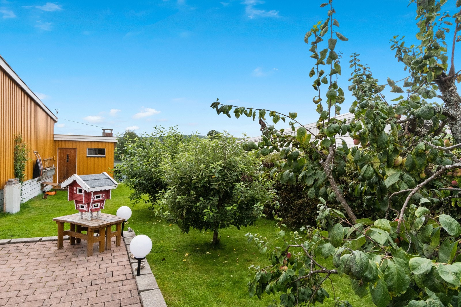 Pent opparbeidet tomt med belegningsstein, diverse beplantninger, plenareal, m.m. Galleribilde