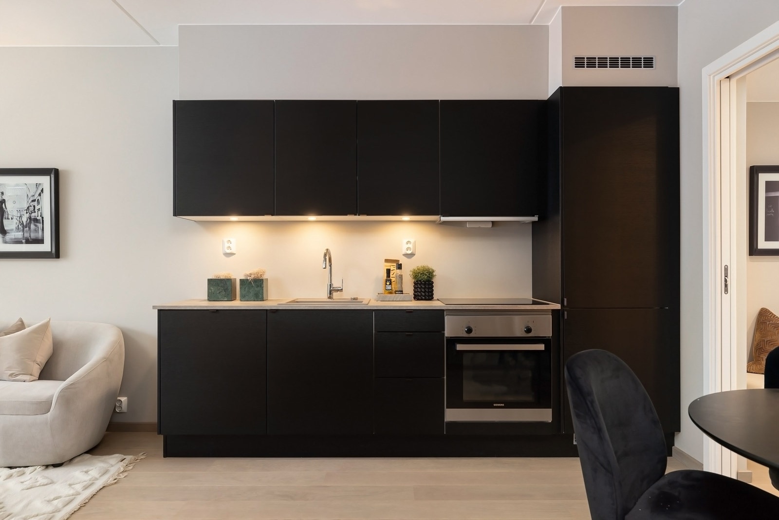 Pent og tidløst kjøkken fra Sigdal med integrerte hvitevarer fra Siemens. Nedfelt vaskekum i stål. Avtrekk over komfyr med uttrekkbar slimlineventilator i stål. Installert aqua-stop som gir trygghet. Galleribilde