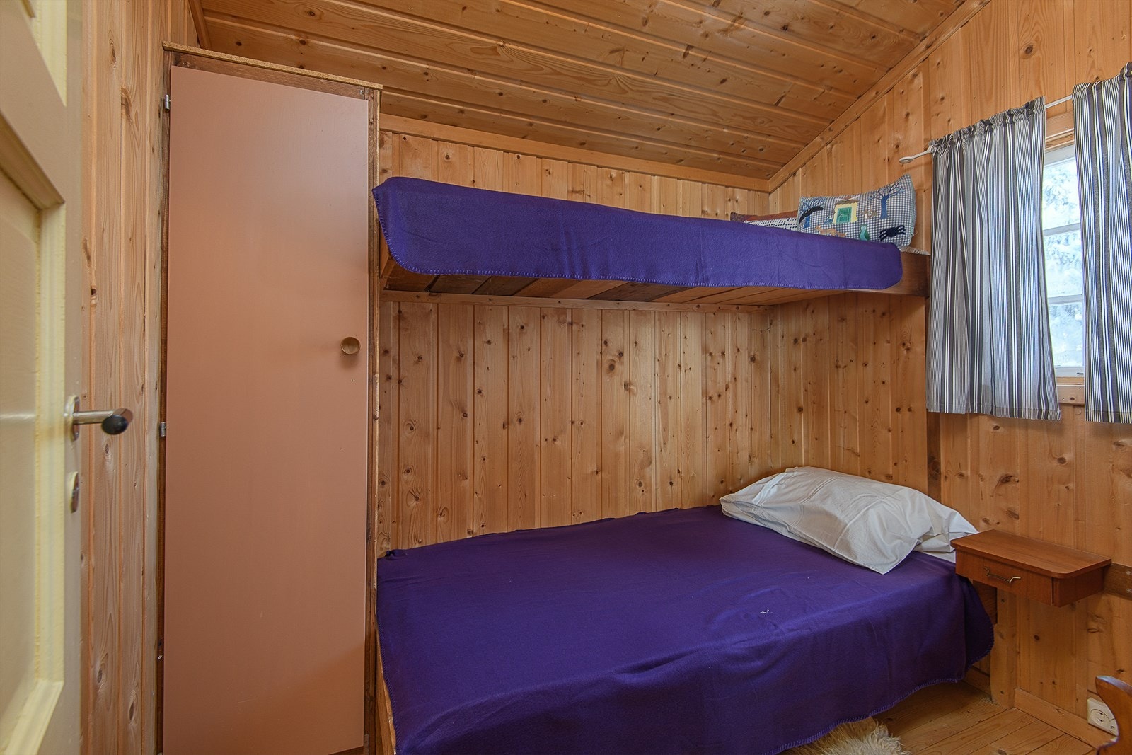 Soverom med plassbygget seng og garderobe Galleribilde