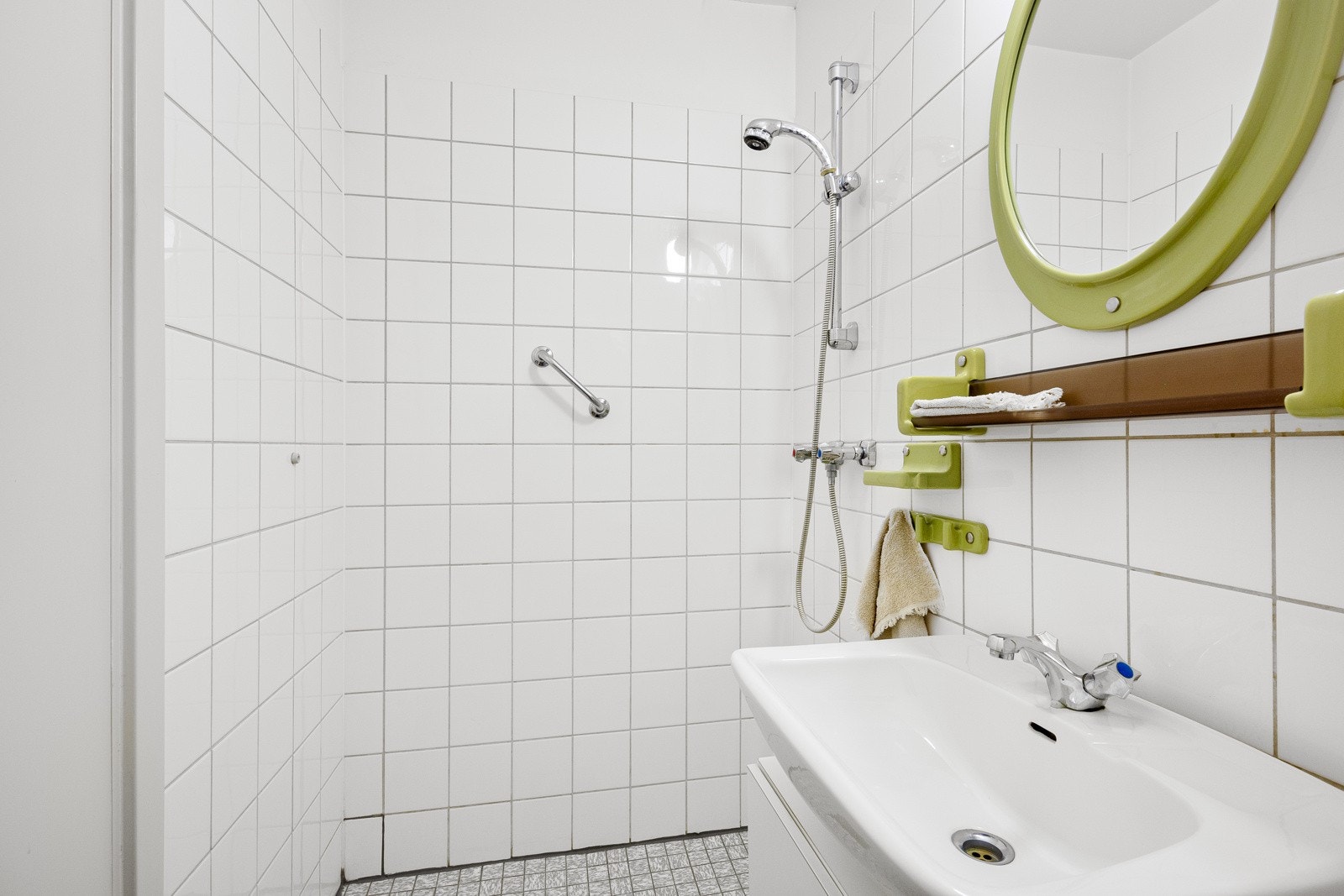 Badet ved entreen er innredet med et åpent dusjhjørne. Galleribilde