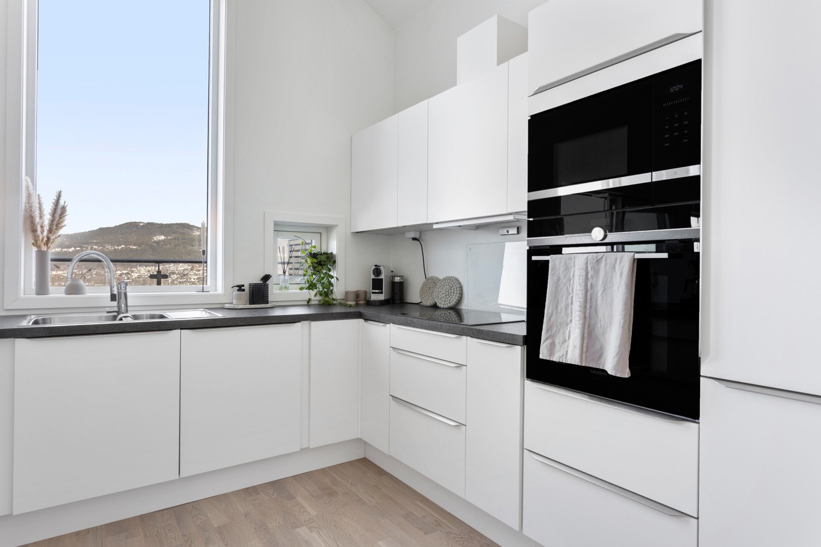 Åpen kjøkkenløsning som har god skap- og benkeplass. Integrert kjøl/frys, mikro, oppvaskmaskin Galleribilde