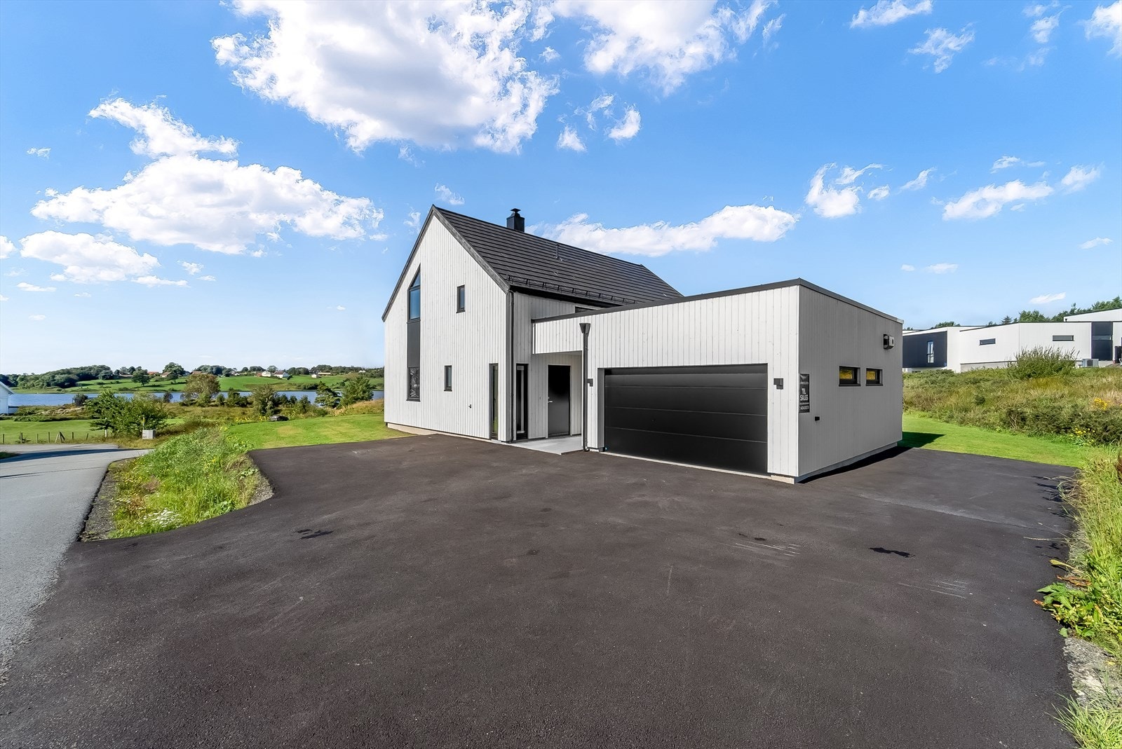 Asfaltert tun med parkeringsplasser. Innkjøring til garasje med automatisk portåpner. Galleribilde