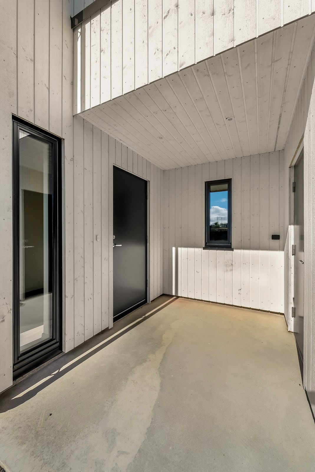 Overbygd entré med inngang til boligen og garasjen. Galleribilde