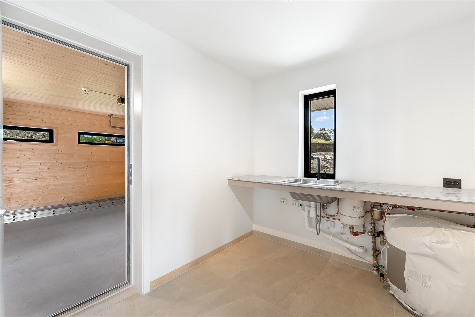 Praktisk vaskerom med adkomst fra kjøkken og garasje. God avkledning/tørkeplass. Galleribilde