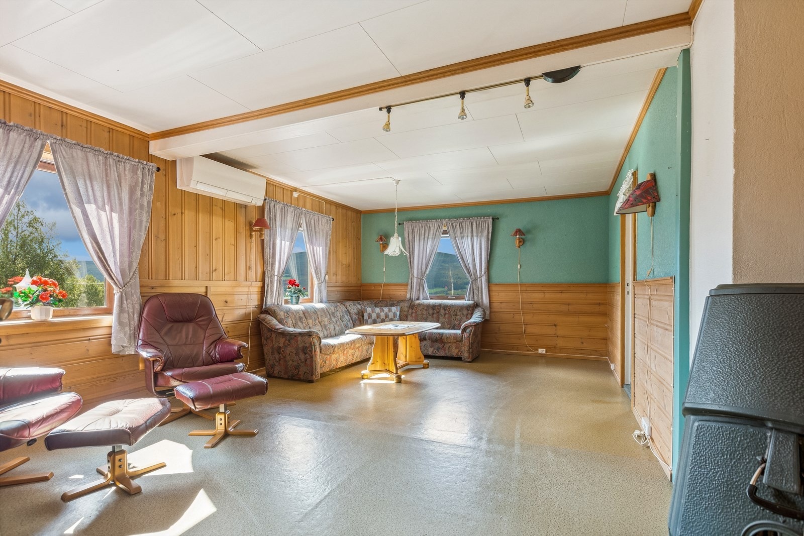 Inne i boligen er det en lys og trivelig stue med mange vinduer som slipper solen inn, og lar en nyte den fine utsikten utover området. Galleribilde