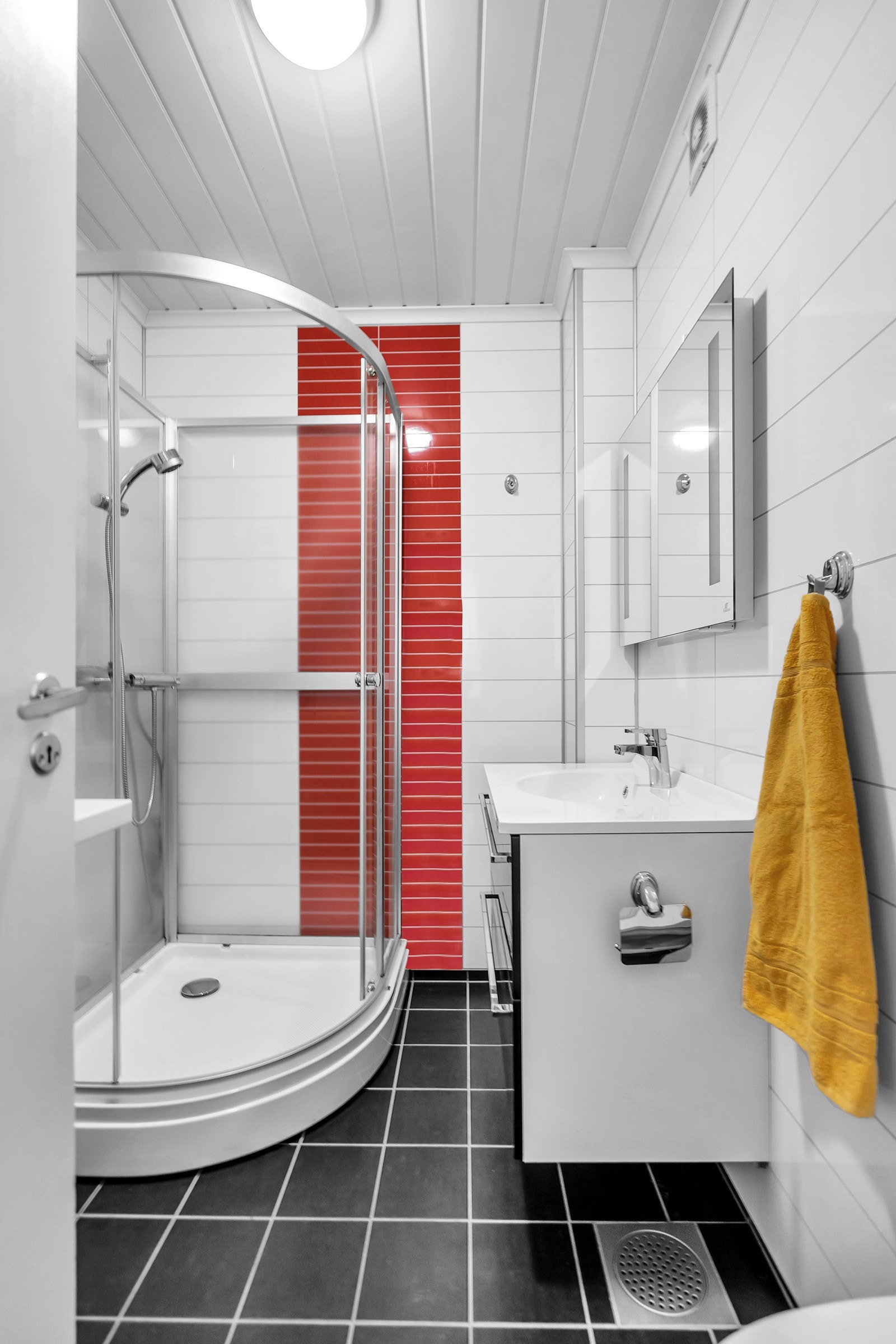 Flott baderom med toalett, servant med innredning, dusjkabinett og opplegg til vaskemaskin Galleribilde