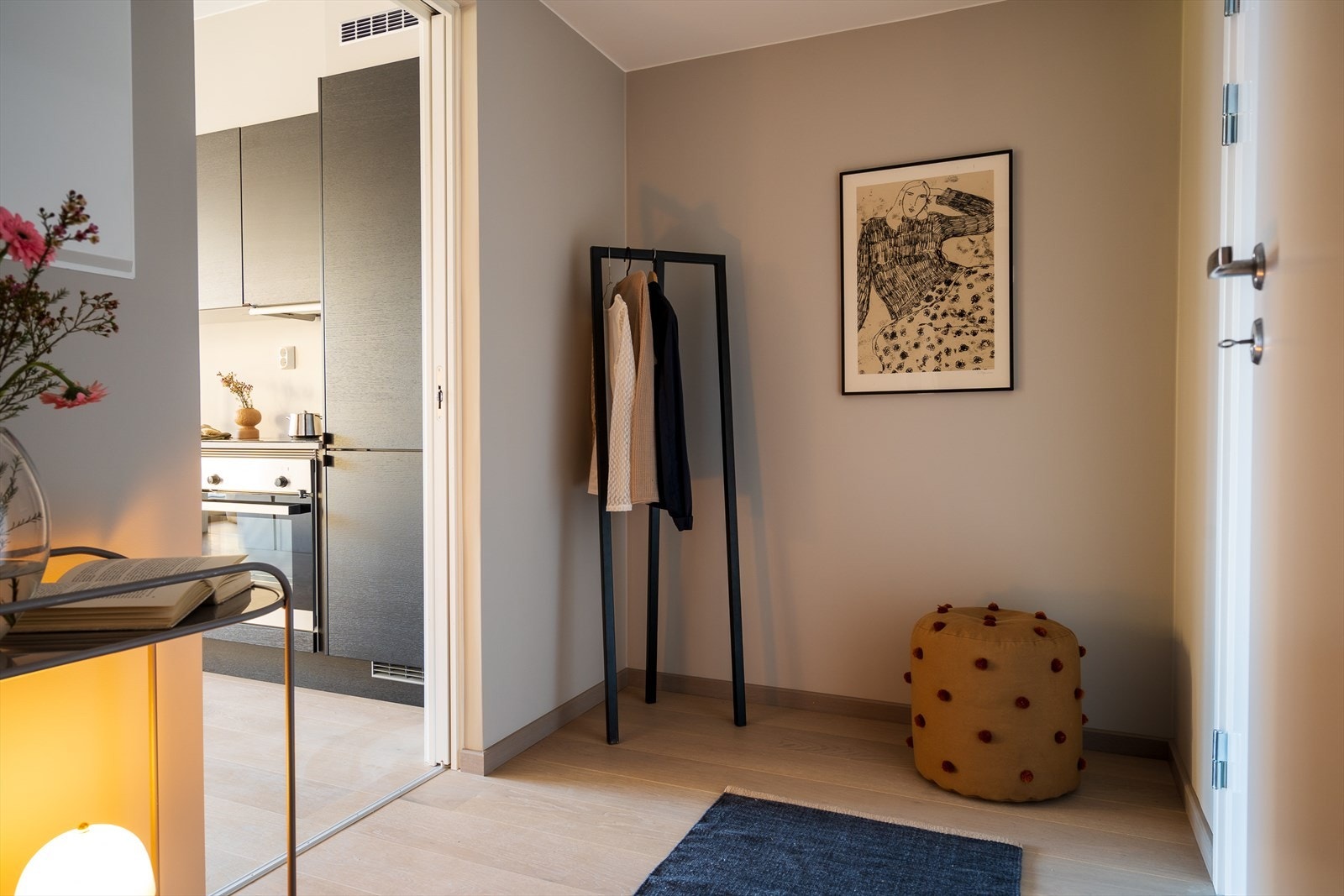 En innbydende entré med downlights og skyvedør inn til kjøkken/stue. Her er det for eksempel plass til et garderobeskap eller kommode for enkel og ryddig oppbevaring av yttertøy og sko. Adkomst via heis elle trapp opp til leilighetsplan. Galleribilde