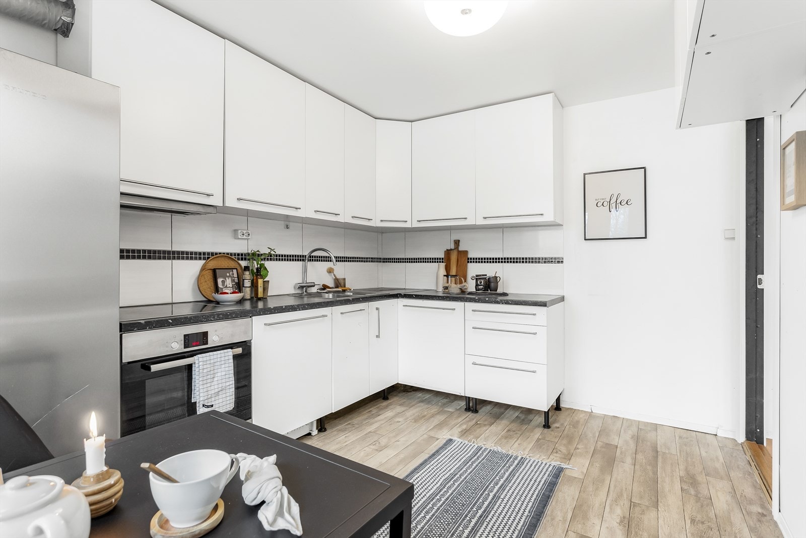 Innredningen er montert i L-form og har integrerte hvitevarer, samt frittstående kjøleskap. Galleribilde