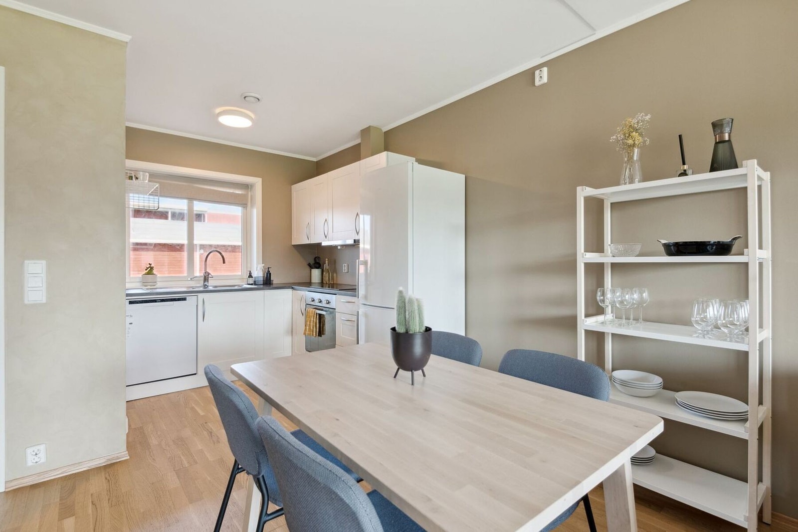 Lyst kjøkken med integrert stekeovn og platetopp som medfølger i handelen. Galleribilde