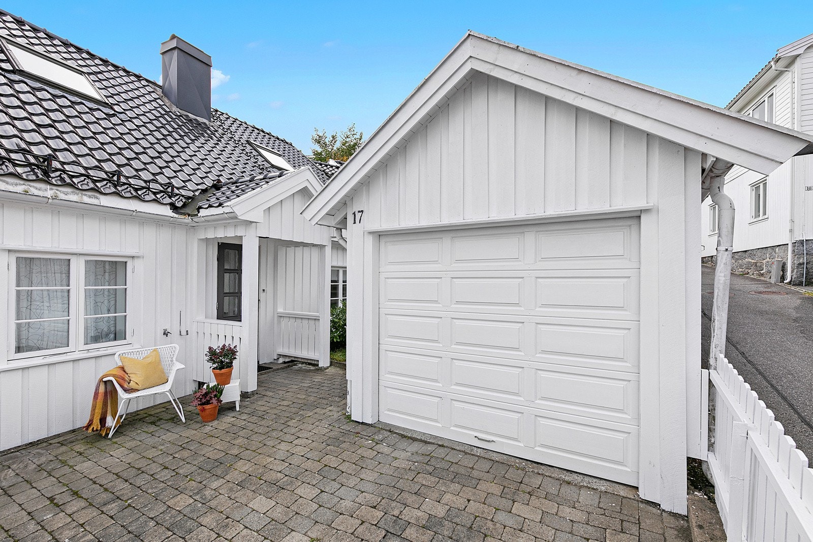 Garasje med bod i bakkant og entré til den opprinnelige delen av huset Galleribilde
