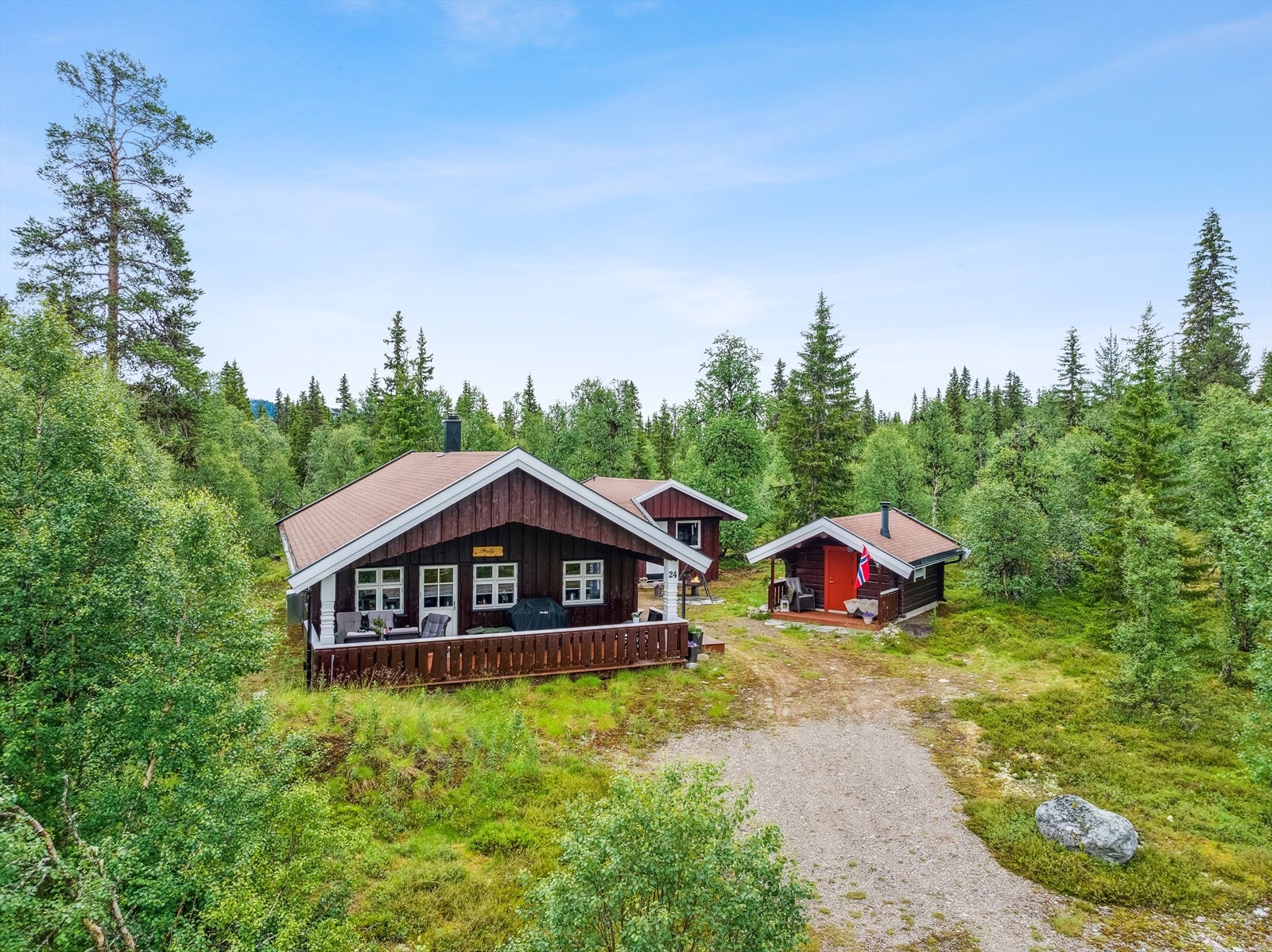 Et trivelig hyttetun med nyere hytte og laftet anneks på romslig selveiet tomt. Galleribilde