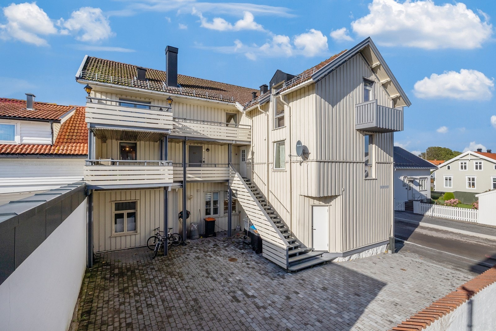 Felles tomt for sameiet, hovedsakelig bestående av steinlagt gårdsplass og biloppstillingsplasser. Galleribilde
