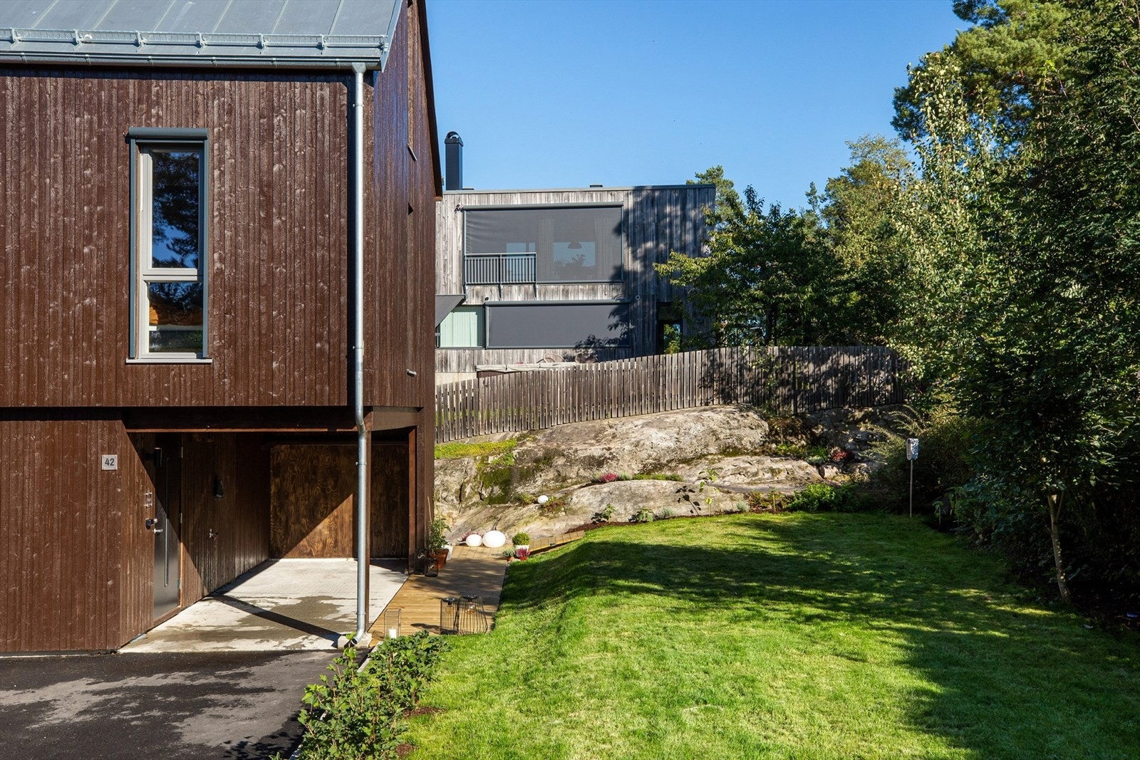 Overbygd inngangsparti fungerer også som carport for liten bil. Galleribilde